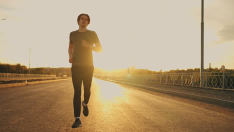 Un-Joven-Atlético-Está-Corriendo-Solo-En-Una-Carretera-Vacía-En-Una-Mañana-Soleada-En-La-Actividad-Deportiva-De-Verano.